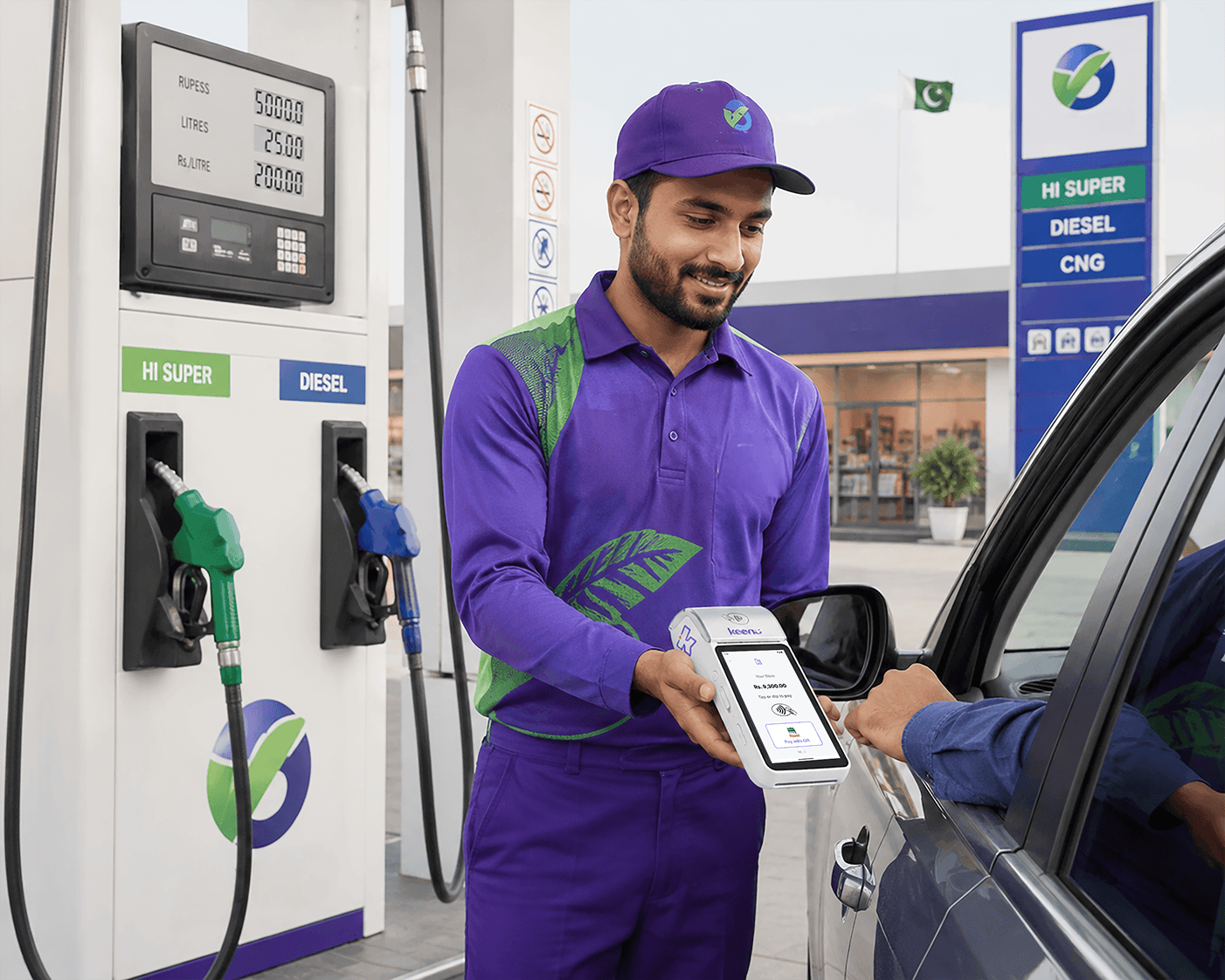 Keenu attendant taking a payment on a handheld terminal from a customer in a car at a fuel station